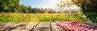 © BG_Illustrations - Wooden Table Overlooking Green Meadow under Blue Sky