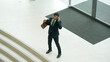 © InfiniteFlow - Professional business man talking to skilled executive manager while standing at door. Top view of manager calling colleague by using phone.while discussing about project plan. Changing job. Exultant.