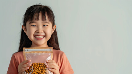 Wall Mural - Advertise our premium pet food, with a smiling Asian girl holding a bag of dog food on a plain white background.