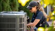 © Vladan - Skilled technician performing maintenance on an outdoor air conditioning unit amidst greenery, showcasing women in trades.