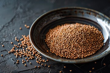 Wall Mural - A bowl of brown seeds is on a dark surface. The bowl is full of seeds and there is a lot of them