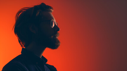 A bearded man with glasses is captured in profile wearing a dark shirt, set against a vibrant red-orange backdrop, creating a dramatic evening silhouette - Generative AI