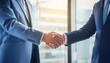 © intricateflow - Two businessman in business suits shaking each other's hands; two professionals greeting each other with a handshake; office or conference meeting room