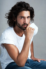 Poster - Casual, fashion and portrait of man in studio with confidence, designer clothes and relax on chair. Jeans, pride and cool male model on stool with creative style, trendy aesthetic or grey background