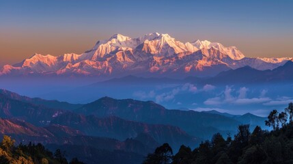 Poster - Panoramic view of a mountain range at sunset with vibrant colors and misty atmosphere