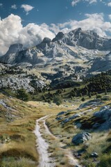 Aufkleber - A dirt road winds through a lush green grassy field, with mountains rising up in the distance