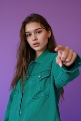 Poster - A woman wearing a green shirt points her finger at the camera, conveying a sense of direction or importance