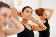 © KayJoint/peopleimages.com - Ballet, girls and hands of dancer tie hair in dance studio, art academy or creative school for practice and training. Student, artist and people in group getting ready for performance or hobby