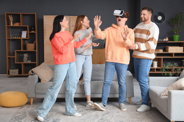 Canvas Print - Young woman with her friends using VR glasses at home