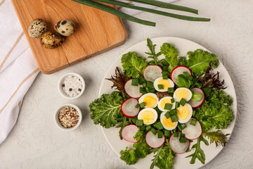 Wall Mural - Plate of fresh salad with boiled quail eggs and spices on light background