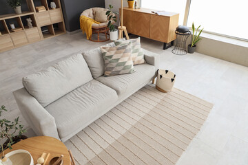 Poster - Interior of modern living room with grey sofa, armchair and drawers