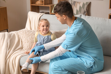 Wall Mural - Male pediatrician examining little girl at home