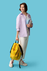 Poster - Beautiful female student with backpack and books on blue background