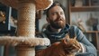 © Emilio - Male cat sitter and red-haired cat seeing at side. Cat portrait next to scratching post. House sitting and feline care service. Furry friend, domestic animal pet photo
