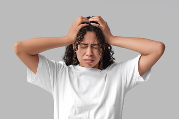 Wall Mural - Young African-American woman having panic attack on grey background