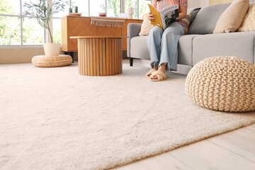 Poster - Woman in slippers reading magazine on sofa and soft carpet at home