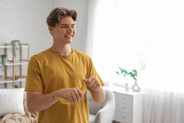 Canvas Print - Young man peeling banana at home