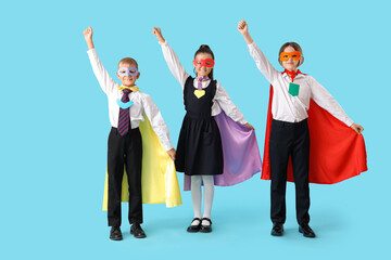 Wall Mural - Happy pupils dressed as superheroes on blue background