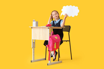 Sticker - Happy schoolgirl with backpack, stationery and blank speech bubble sitting on desk against yellow background