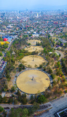 Aerial view of Chapultepec Forest in the foreground with the sprawling City of Mexico skyline in the background, showcasing urban and natural contrasts