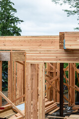 Wall Mural - Closeup detail of new house construction, large glue laminate wood support beams and Parallel Strand Lumber support beams, building framing started with walls and windows
