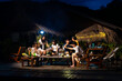 © CandyRetriever  - Group of Young Asian man and woman friends enjoy and fun celebration meeting dinner party eating barbecue grill and drinking beer together on lake house balcony on summer holiday vacation at night.