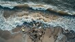 © HanThar Fusion - aerial view of the ocean waves crashing onto an overcast beach, with scattered plastic bottles and other debris on its shore