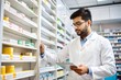 © N7 - Indian Pharmacist Organizing Medicine Boxes on Pharmacy Shelves