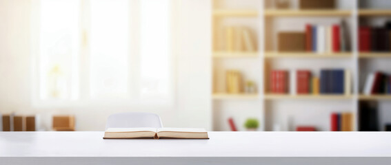 Poster - Open book on a white desk with a blurred home office background with a bookcase full of books