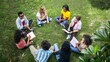 © Felippe Lopes - Diverse group of young adults sit in a circle on the grass, engaged in conversation.