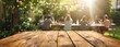 © Simon - Empty wooden table and blurred view of a group of people having BBQ barbecue outdoors. Wood desk in front of a natural garden background. Summer lifestyle concept.