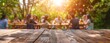 © Simon - Empty wooden table and blurred view of a group of people having BBQ barbecue outdoors. Wood desk in front of a natural garden background. Summer lifestyle concept.