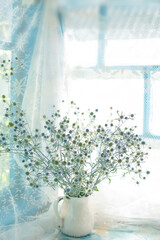 Wall Mural - A bouquet of dried flowers in a ceramic jug on an old wooden window in a country house.