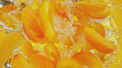 Aufkleber - Super Slow Motion of Falling Apricots Slices into Water, Colored Background. Filmed on High Speed Cinema Camera, 1000 fps. Camera Tracking the Target.