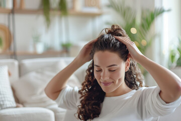 Smiling young woman is massaging her scalp with closed eyes, taking care of her hair after washing, stimulating hair growth