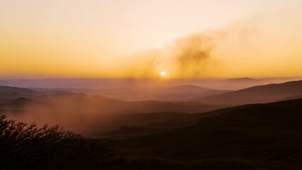 Wall Mural - Stunning sunset over mountains with vibrant sky and rolling landscape