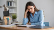 © yevhen89 - Tired girl sits in office at her workplace and holds her head. Emotional burnout