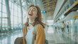 © VK Studio - A joyful young woman, with hair flowing, laughs heartily in an airy, modern airport terminal, embodying the essence of carefree travel.