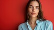 © LOMOSONIC - Confident Businesswoman in Light Blue Blouse Evoking Tranquility and Boldness on Red Background