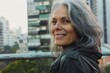 © darshika - natural portrait of older woman with gray hair in the city  smiling and looking at infinity.