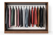 © tonstock - Elegant wooden wardrobe with a variety of clothes hanging on black hangers, showcasing colorful and neatly arranged garments in a modern closet.