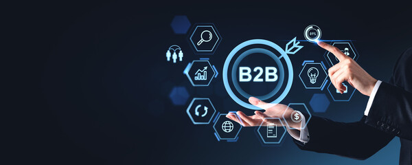 Fototapete - Businessman's hands with B2B hologram icons on dark background.