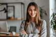 © Nognapas - Portrait of young smiling woman looking at camera with crossed arms. Happy girl standing in creative office. Successful businesswoman standing in office with copy space.