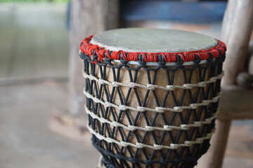 Folklore drum, decorated with rope knots net. Concept, musical instrument. Beat drum with rhythm along music and songs for entertainment. Vintage and traditional style. Hand drum.       