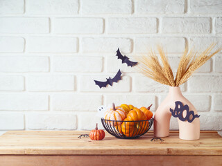 Wall Mural - Halloween background with modern vase and decoration on wooden table over brick wall. Empty space for product display