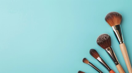 Wall Mural - Makeup brushes and cosmetics composition on blue backdrop