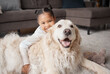 © Lumeez23/peopleimages.com - Girl, dog and portrait on floor in house for support, safety and playing together with love or care. Young child, happy and golden retriever on ground in home for pet growth, security and development
