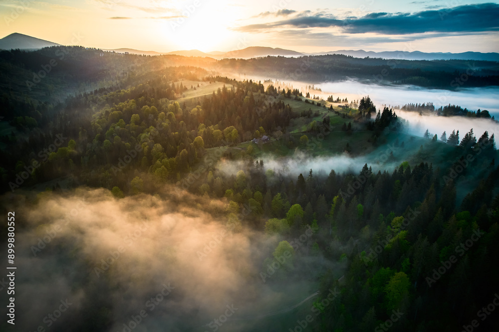 Aerial view of breathtaking sunrise over misty landscape with rolling ...