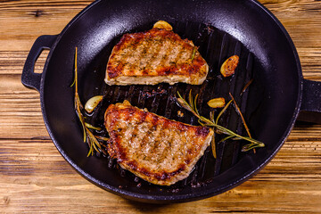 Wall Mural - Roasted steaks with garlic, rosemary and spices in a cast iron grill pan