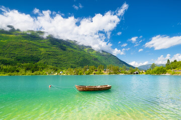 Wall Mural - wooden boat on a mountain lake in a norwegian fjord. nature in fjords. high mountains and reflection